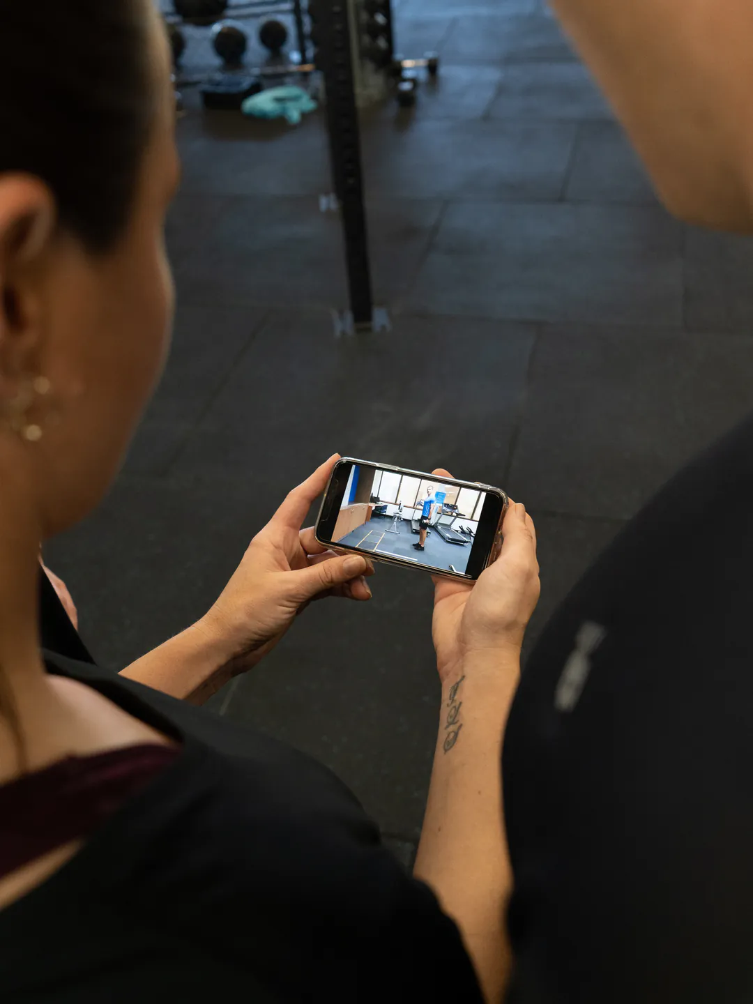 A client checking their training program on a phone at the gym