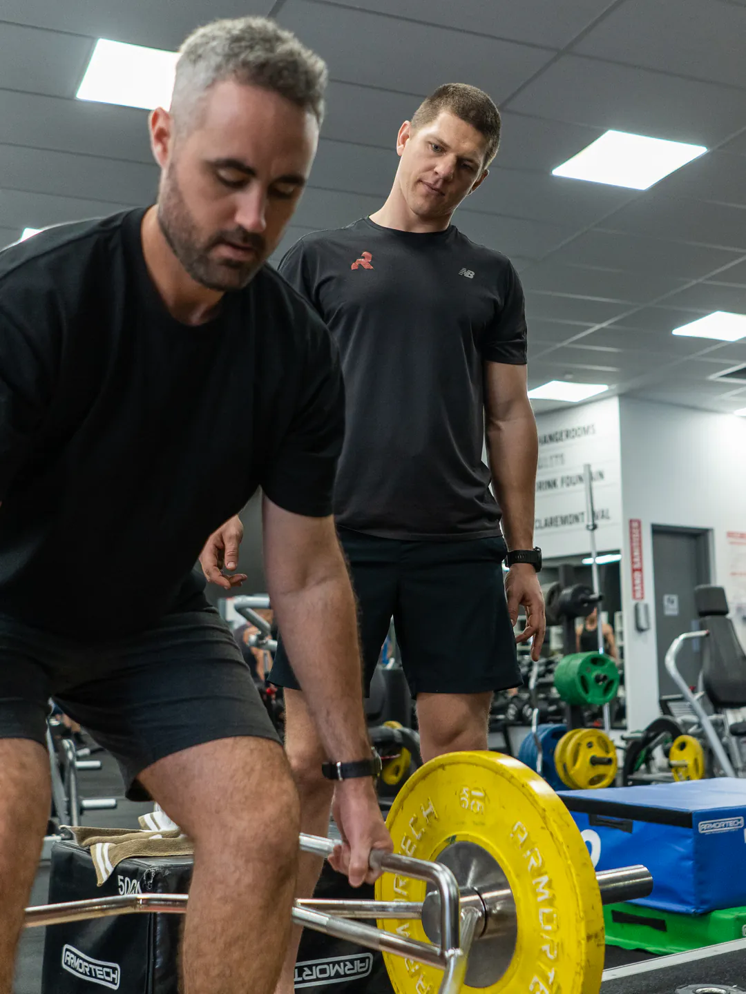 A Conditioning Co coach cueing a client through a lift, one to one